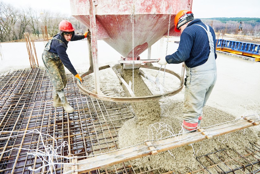 Travailleurs manipulant une benne à béton